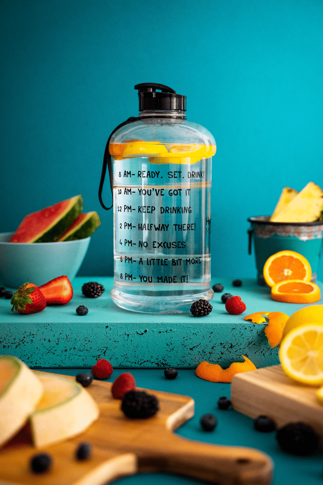 A Photo Of Berries, Lemons, Oranges And A Bottle Of Water.